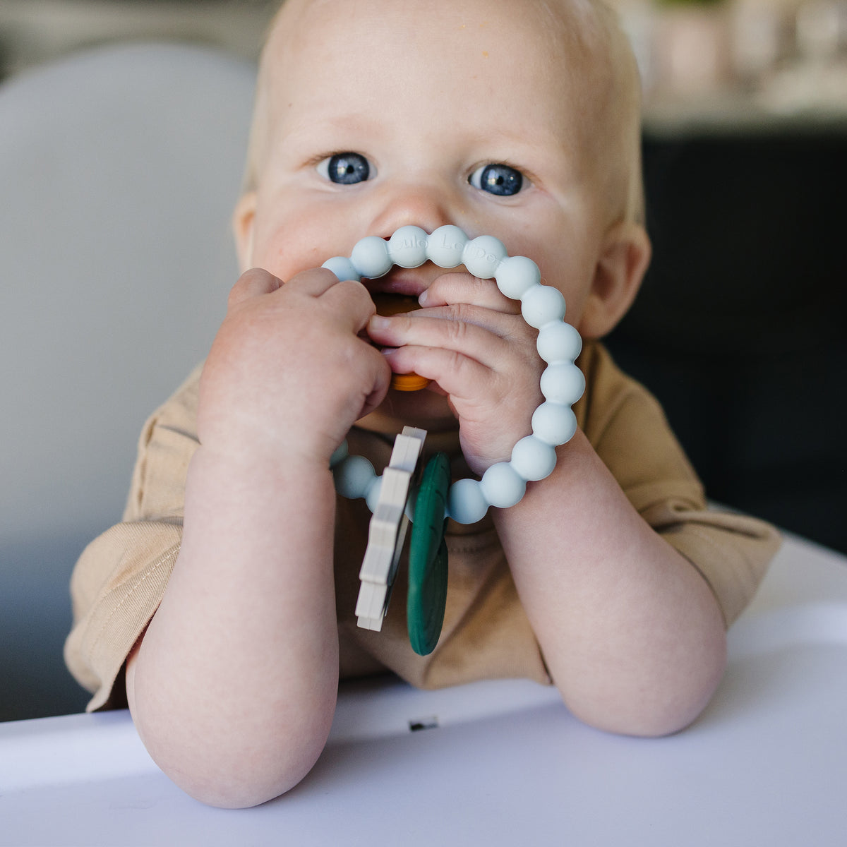 Baby chewing on a teething ring silicone charms.