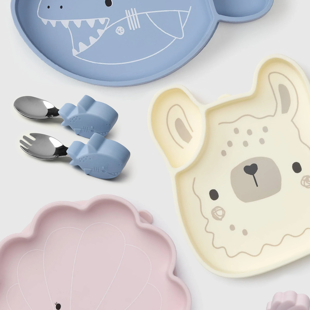 Set of children's plates and utensils with animal designs on a white background