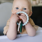 Baby chewing on a teething ring silicone charms.