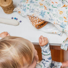Child playing with colorful fabric on a table