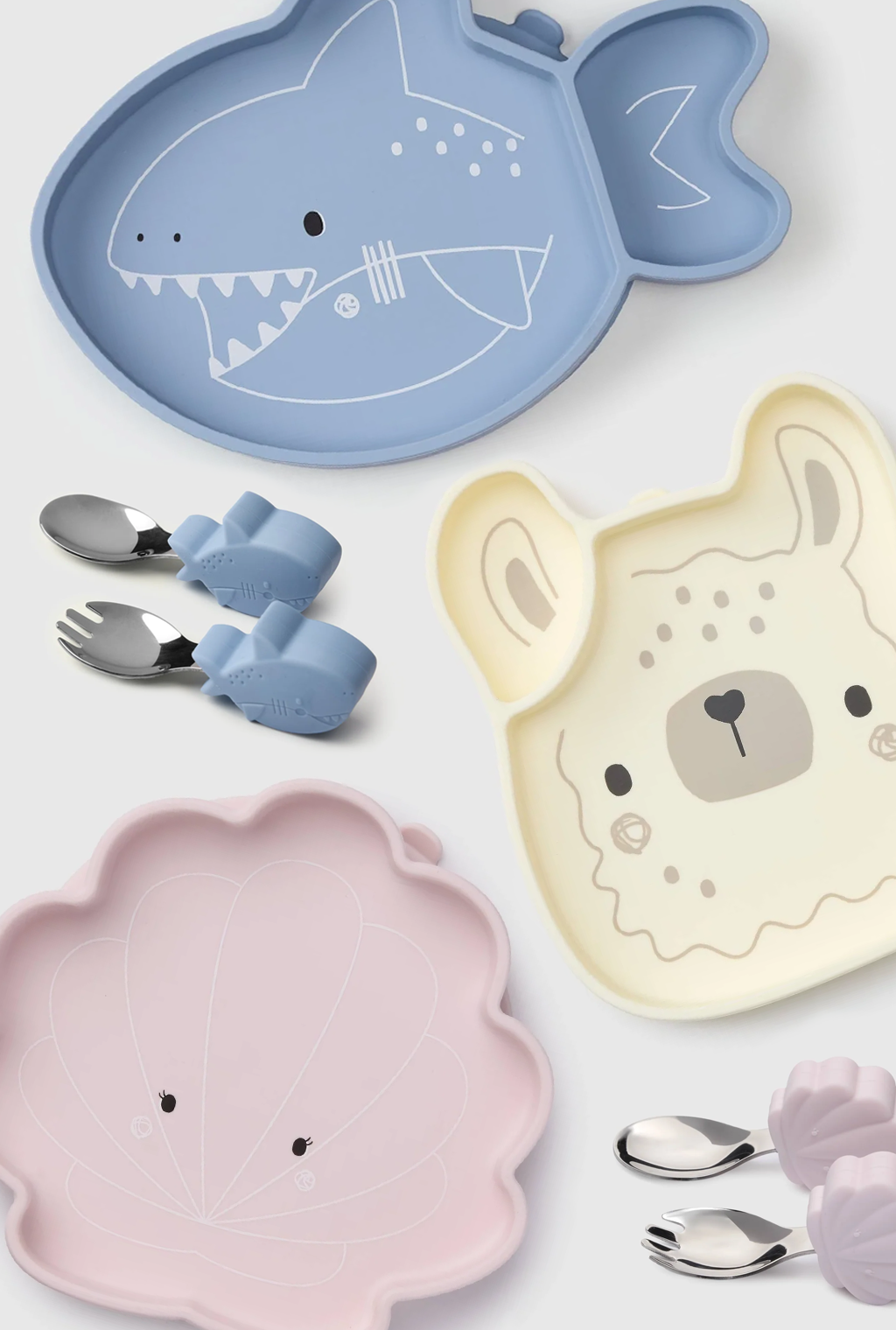 Set of children's plates and utensils with animal designs on a white background